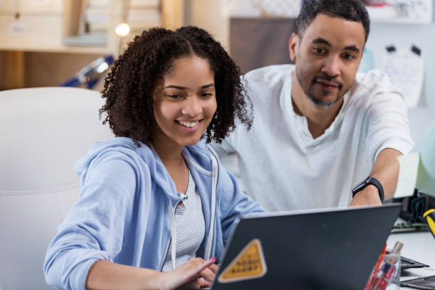 A father takes time to help his daughter find the video she needs to be able to finish her school project.